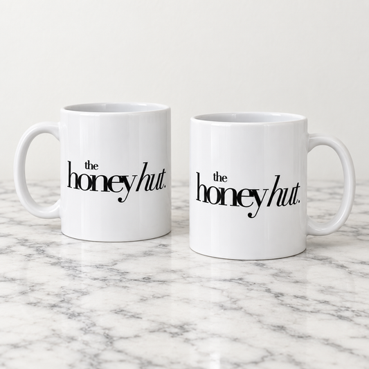 Two white ceramic business mugs printed with The Honey Hut black logo