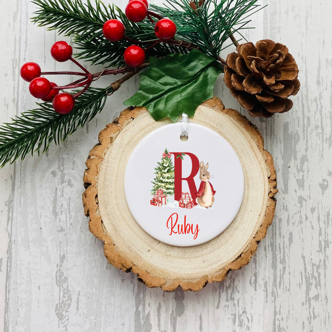 Personalised ceramic Christmas bauble with festive floral initial, name and optional year