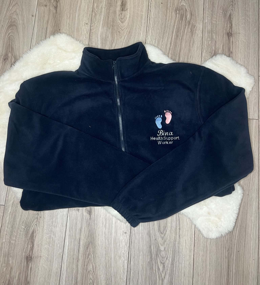 Navy fleece with pink and blue baby footprints embroidered above Bina and Health Support Worker wording