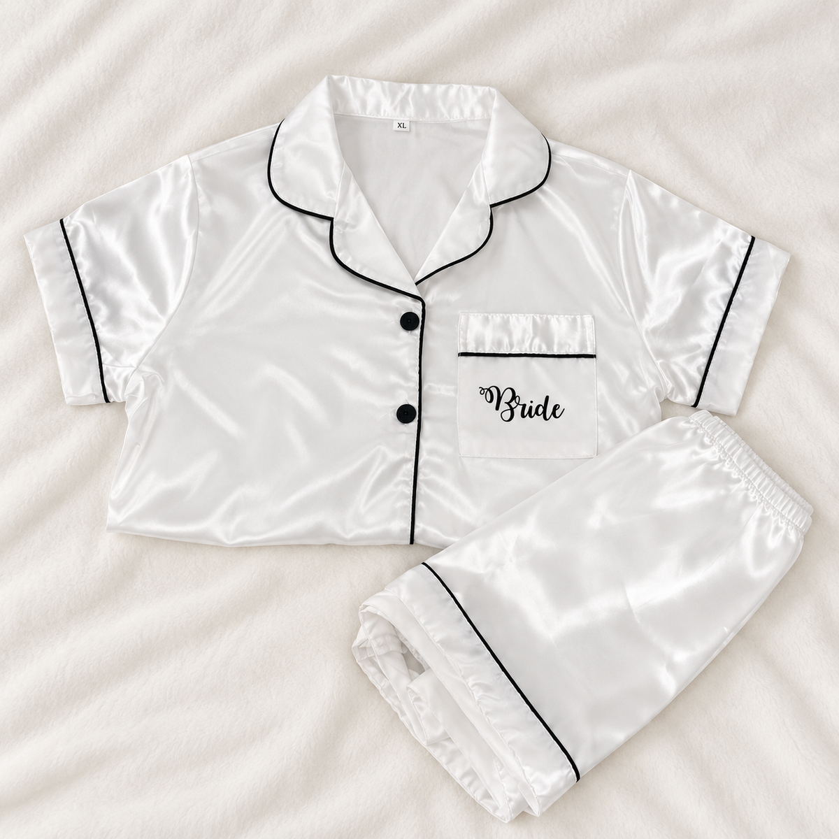 White personalised bridal satin pyjamas with black piping and Bride printed on the front pocket