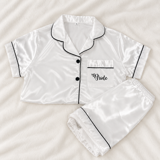 White personalised bridal satin pyjamas with black piping and Bride printed on the front pocket