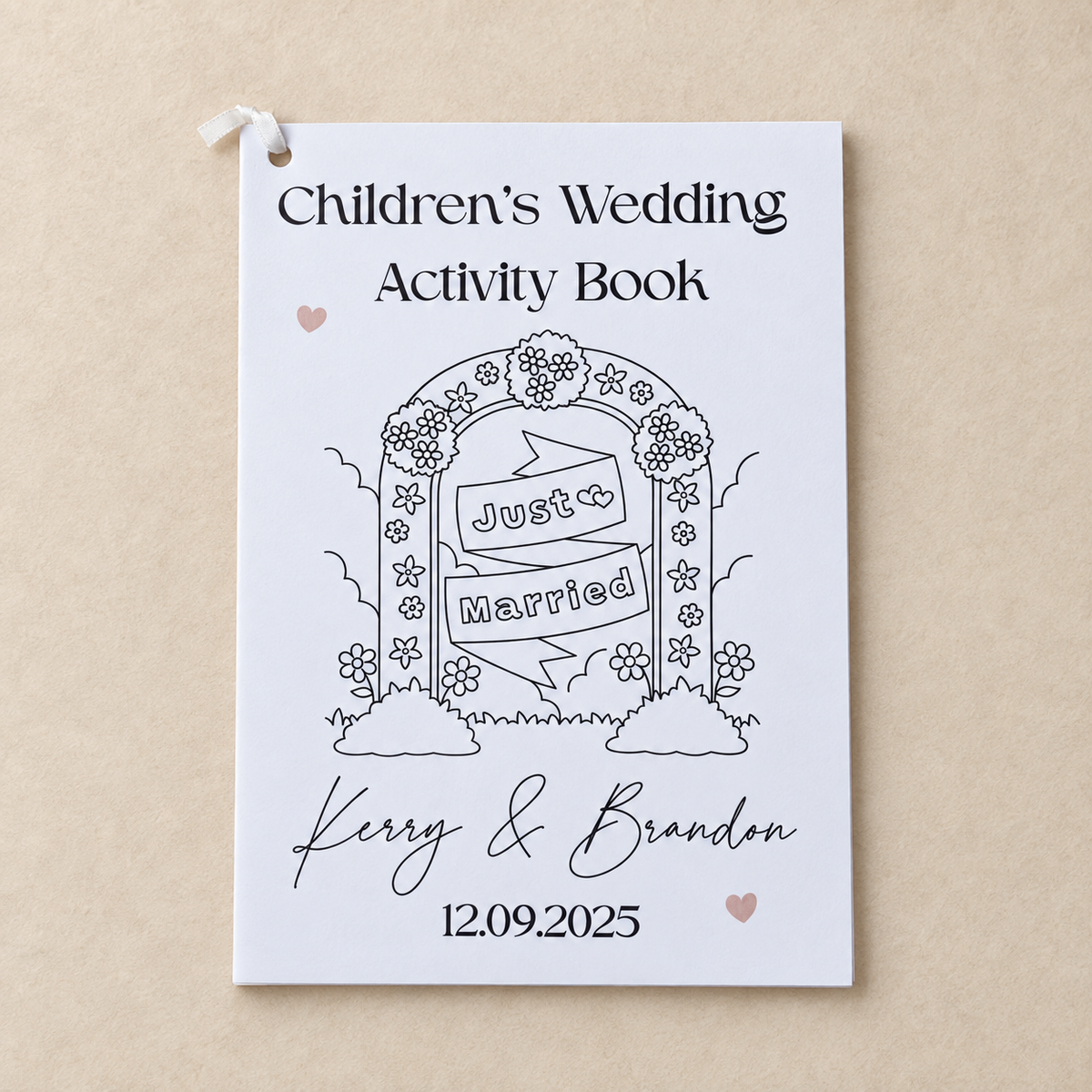 Personalised children’s wedding activity book with Just Married cover on a warm beige background