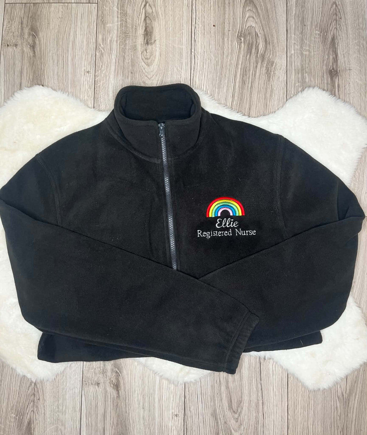 Black fleece with multicoloured rainbow embroidery, Ellie name and Registered Nurse wording