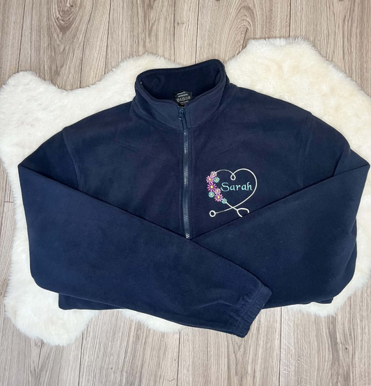 Navy fleece embroidered with a white stethoscope heart, colourful flowers and Sarah name