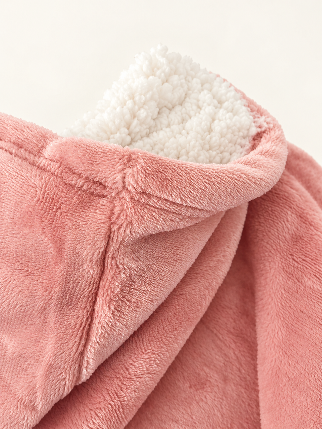 Sherpa lining detail of children's blush pink hooded blanket