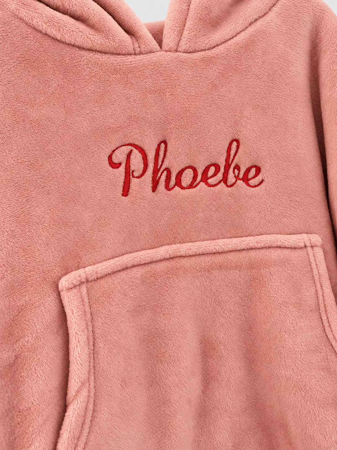 Embroidered name detail on blush pink hooded blanket