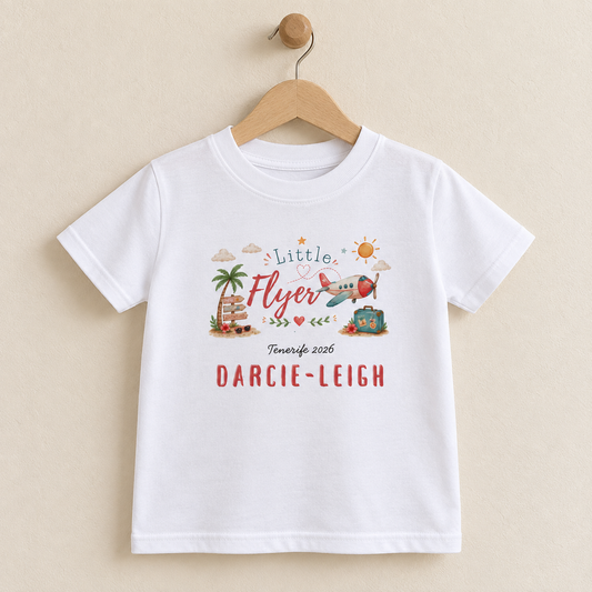Personalised Little Flyer children's white T-shirt displayed on a wooden hanger against a warm beige background