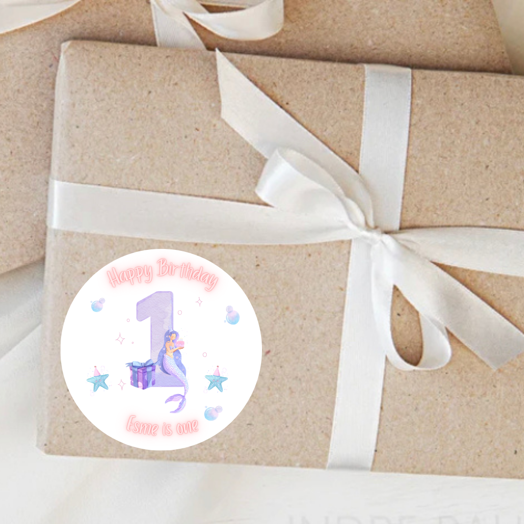 Gift box wrapped in brown paper with a white ribbon and a birthday sticker on a light background